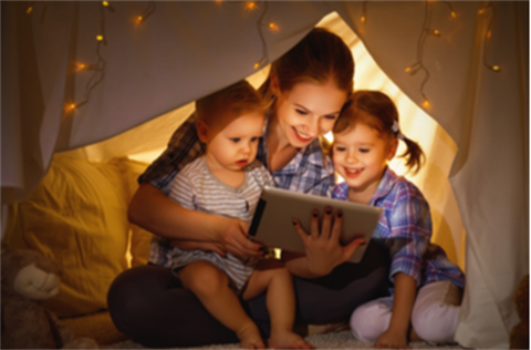 Mother and children reading under blanket