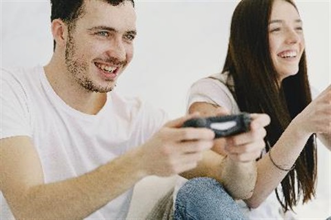 girl and boy holding gaming consoles