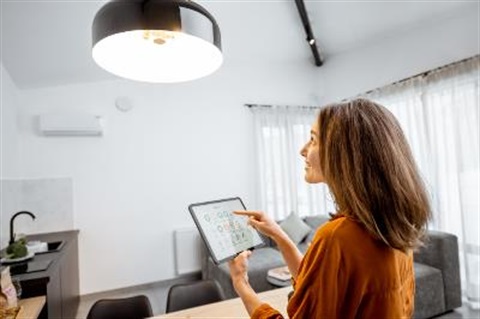 lady using smart device to turn on house lighting